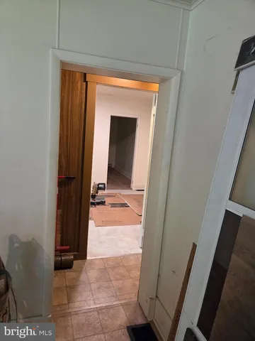 a view of a hallway with wooden floor and a bathroom