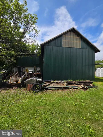 a side view of a house with backyard and sitting area