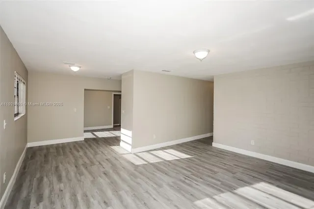 a view of an empty room with wooden floor