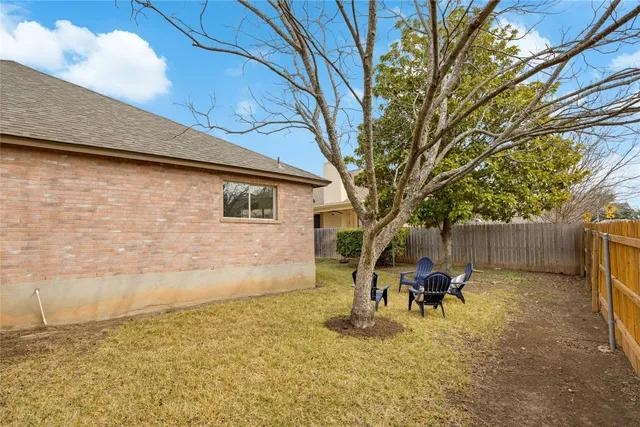 a backyard of a house with table and chairs