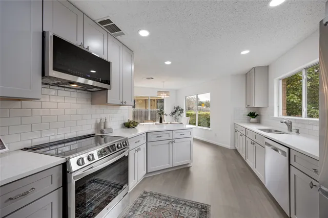 a kitchen with a sink stove and microwave