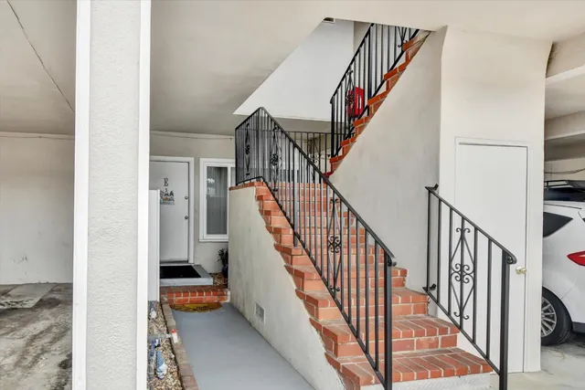 a view of staircase with lots of frames on wall and stairs
