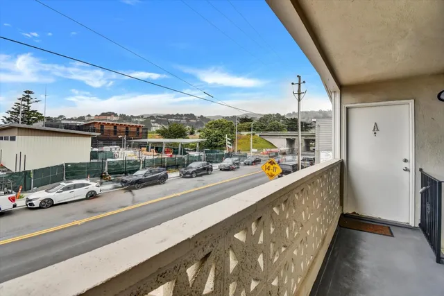 a view of a balcony with cars parked