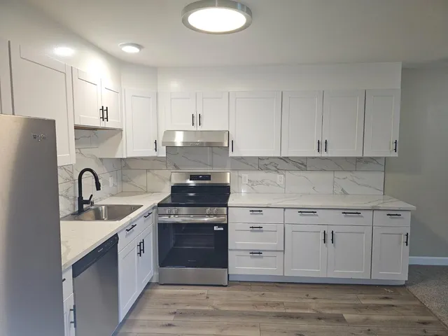 a kitchen with a sink stove and cabinets