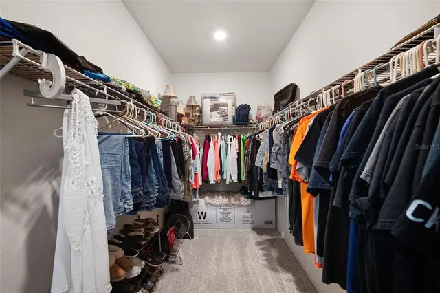 a view of walk in closet with clothes and shoes