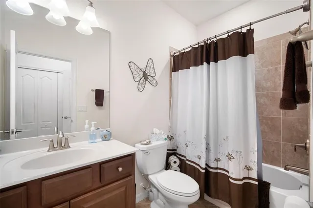 a bathroom with a sink vanity mirror and toilet