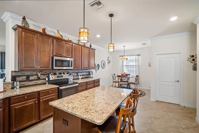a kitchen with granite countertop a sink a stove and refrigerator