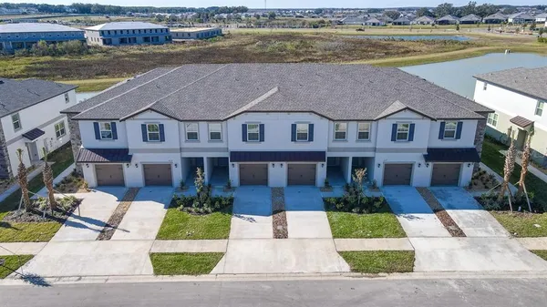 a front view of a house with a garden and lake view