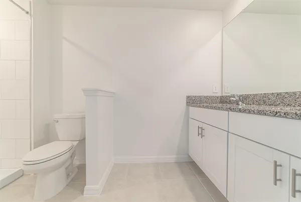 a bathroom with a granite countertop toilet and a sink