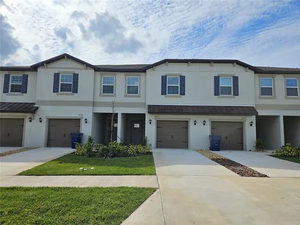 a front view of a house with a garden and garage