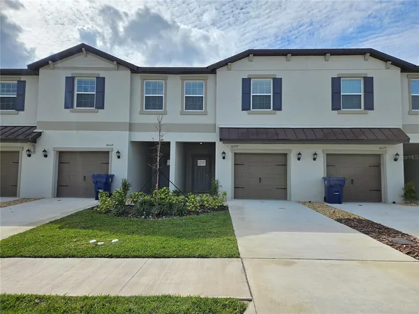 a front view of a house with a garden and plants