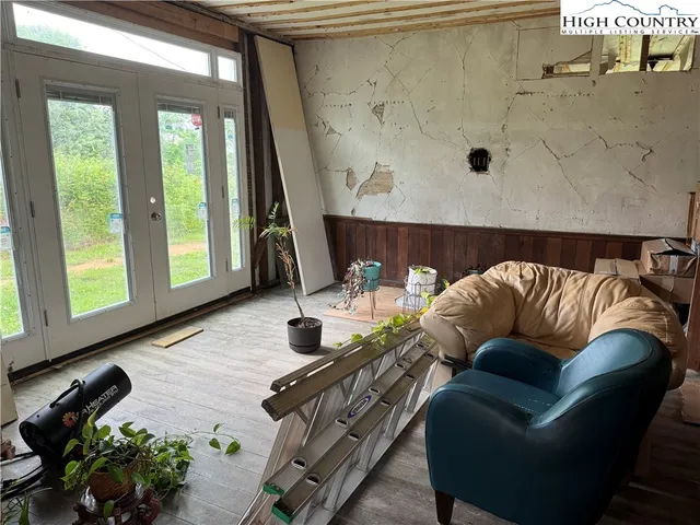 a bedroom with a bed and large windows