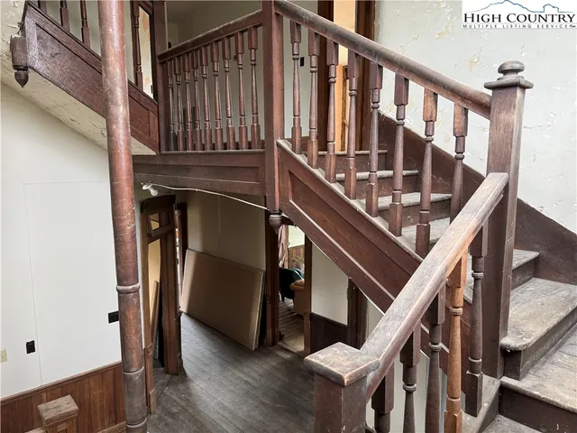 a view of a hallway with wooden floor and staircase