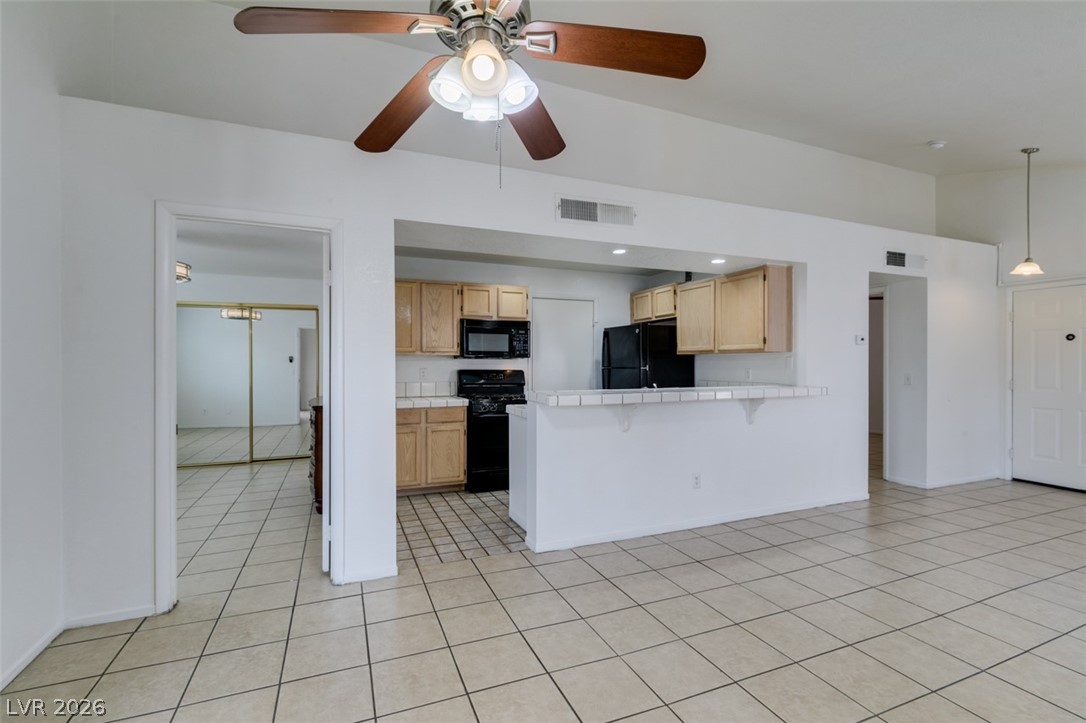 7570 West Flamingo Road, Unit 252 Las Vegas, NV 89147 - Photo 19 of 44 An inviting open-concept layout connects the kitchen to a spacious living area, highlighted by a practical breakfast bar.