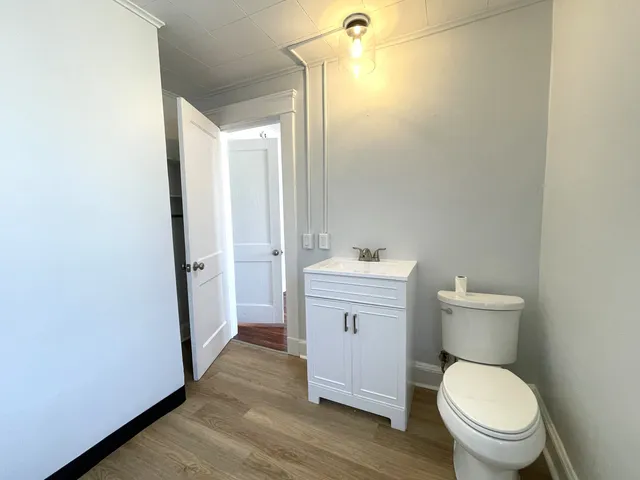 a bathroom with a toilet a sink a mirror and vanity