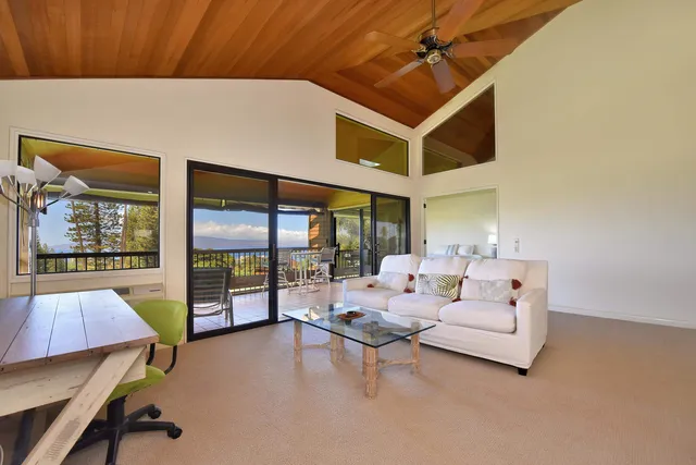 a living room with furniture and large windows