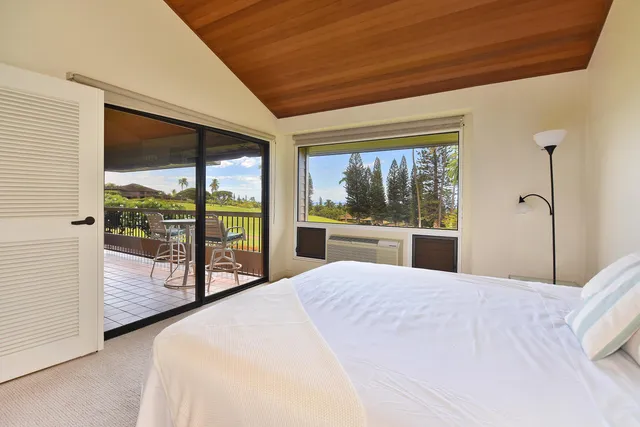 a spacious bedroom with a bed a table and chairs