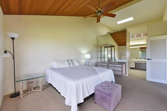a large en suite bathroom with a granite countertop sink and a large mirror