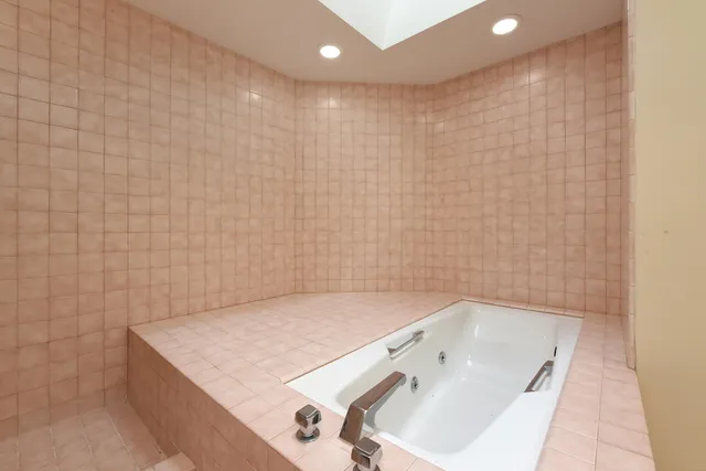 a bathroom with a bathtub sink and mirror