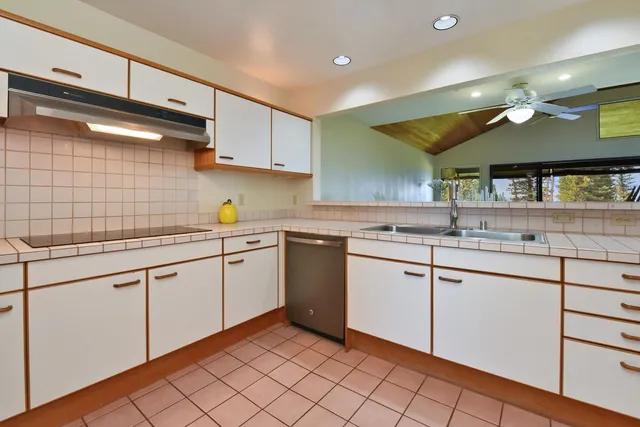 a kitchen with a stove and white cabinets