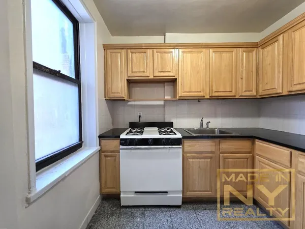 a kitchen with granite countertop white cabinets and white appliances