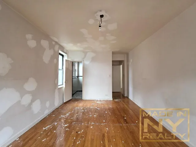 a view of a hallway with wooden floor and a ceiling fan