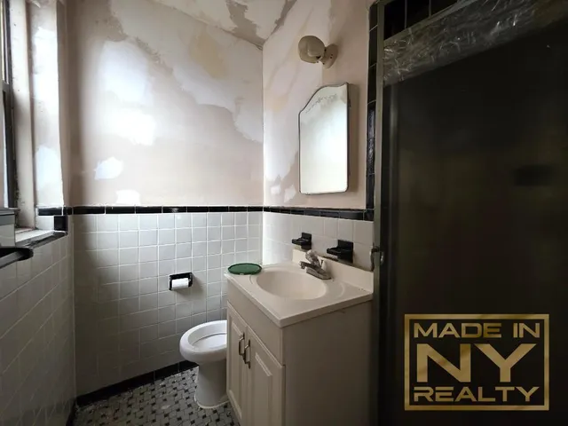 a bathroom with a toilet sink and mirror