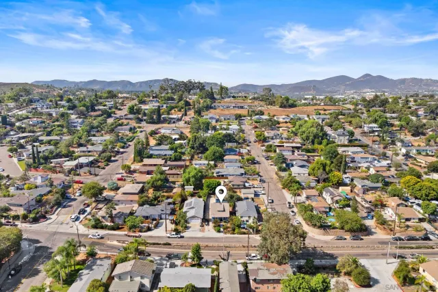an aerial view of residential houses with outdoor space and trees