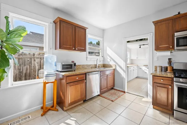 a kitchen with stainless steel appliances granite countertop a stove a sink and a microwave