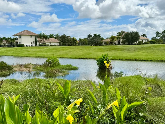 an aerial view of a house with a garden and lake view