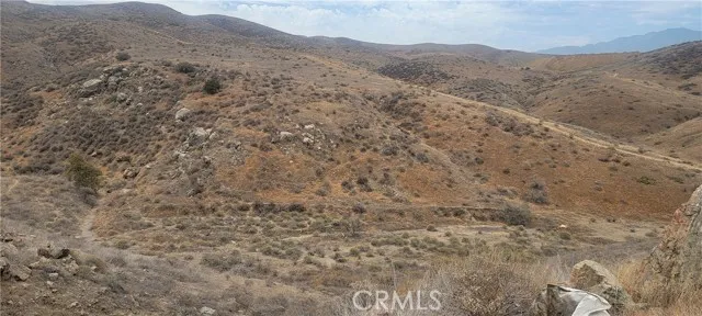 a view of a dry yard with mountains in the background