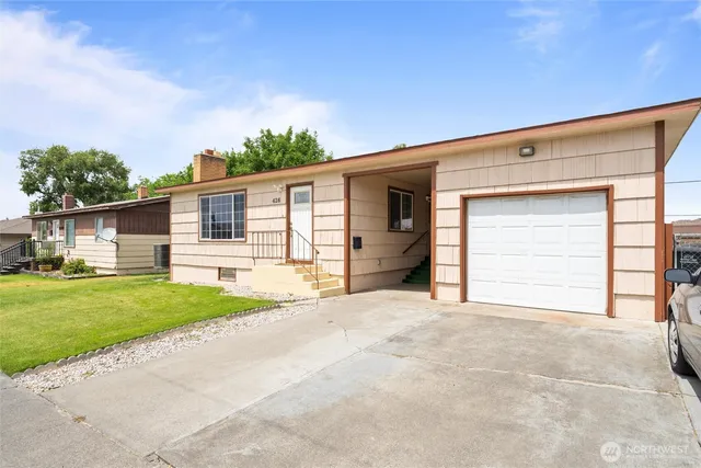 a view of a house with a backyard and a garage