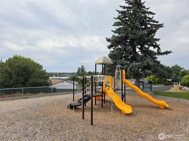 an aerial view of a city with lots of residential buildings and mountain view in back