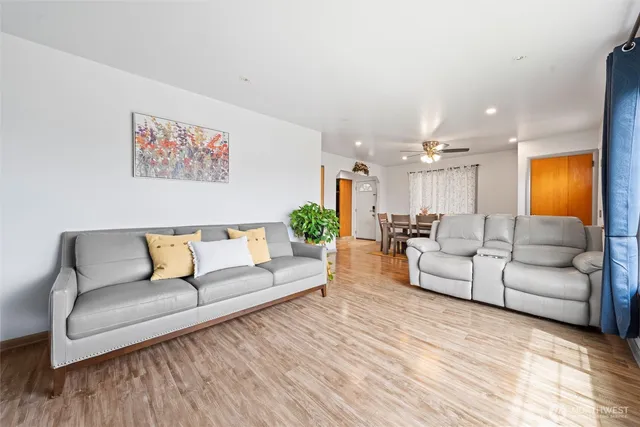 a living room with furniture and a large mirror with wooden floor