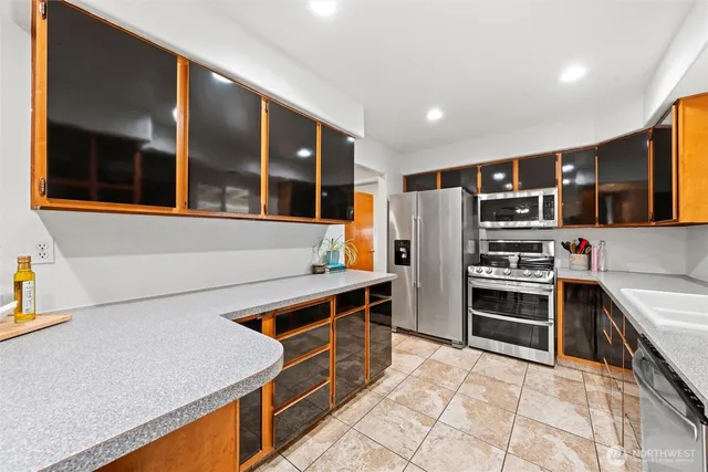 a kitchen with stainless steel appliances granite countertop a refrigerator and a stove