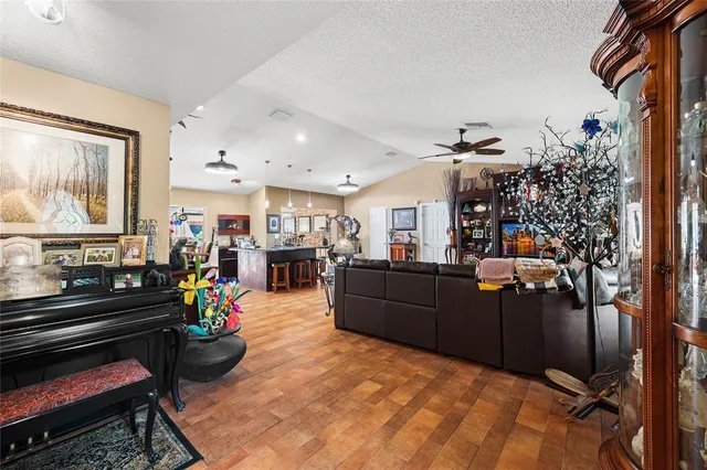 a kitchen with stainless steel appliances kitchen island granite countertop a table chairs and a refrigerator