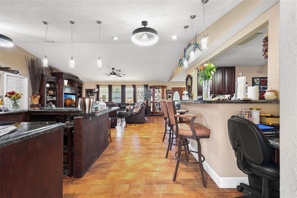 9700 Northwest 28th Street Hollywood, FL 33024 - Photo 16 of 76 a kitchen with stainless steel appliances kitchen island granite countertop a table chairs and a refrigerator