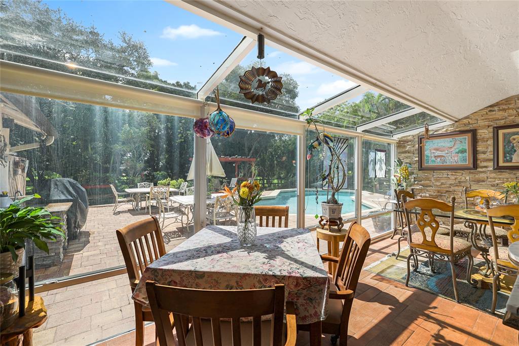 9700 Northwest 28th Street Hollywood, FL 33024 - Photo 17 of 76 a view of a patio with table and chairs potted plants with wooden floor and fence