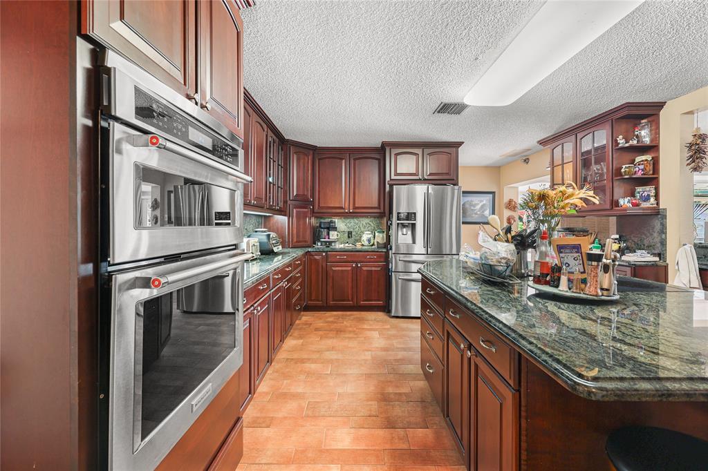 9700 Northwest 28th Street Hollywood, FL 33024 - Photo 25 of 76 a kitchen with stainless steel appliances granite countertop a stove and a sink