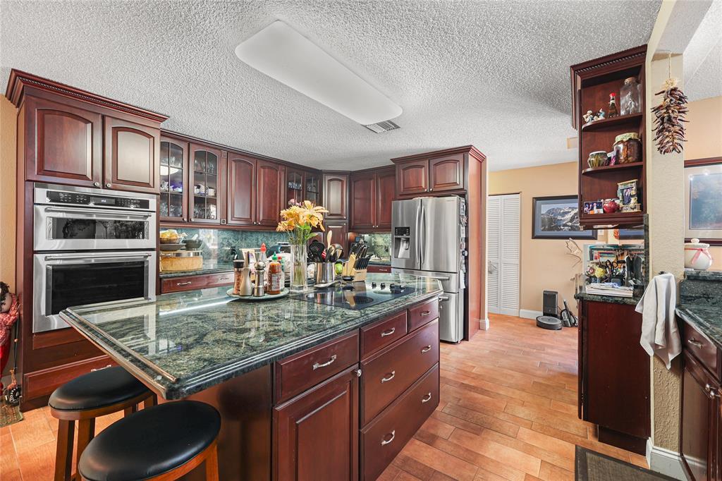 9700 Northwest 28th Street Hollywood, FL 33024 - Photo 26 of 76 a kitchen with stainless steel appliances granite countertop a refrigerator stove and oven