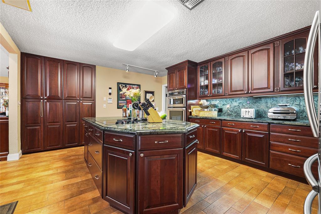 9700 Northwest 28th Street Hollywood, FL 33024 - Photo 29 of 76 a kitchen with stainless steel appliances granite countertop a stove refrigerator and cabinets