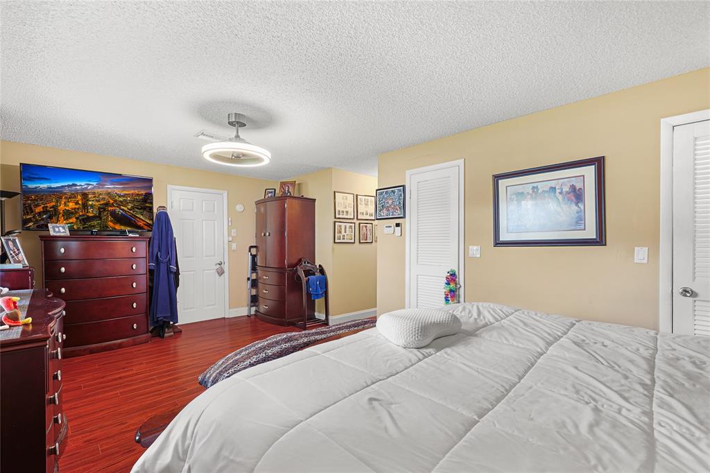 9700 Northwest 28th Street Hollywood, FL 33024 - Photo 32 of 76 a bedroom with a bed and a flat tv screen on dresser
