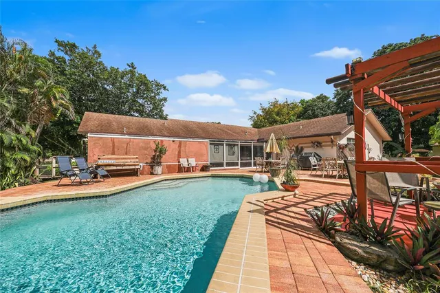 a view of a house with a big yard and large trees