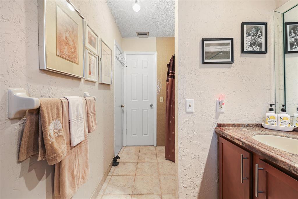 9700 Northwest 28th Street Hollywood, FL 33024 - Photo 63 of 76 a bathroom with a granite countertop sink a mirror and shower