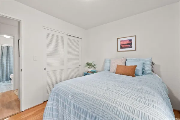 a bedroom with a bed and wooden floor