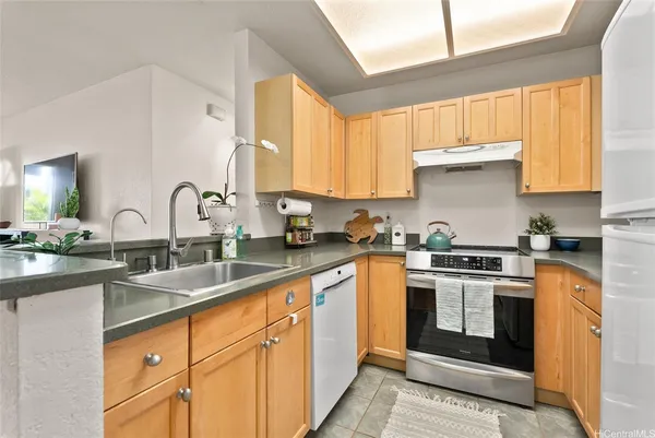 a kitchen with stainless steel appliances granite countertop white cabinets sink and window