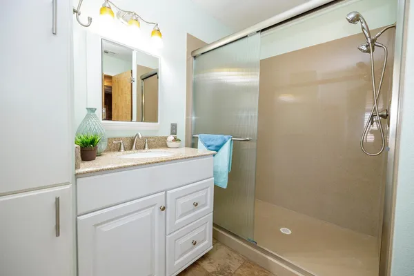 a bathroom with a shower sink and mirror