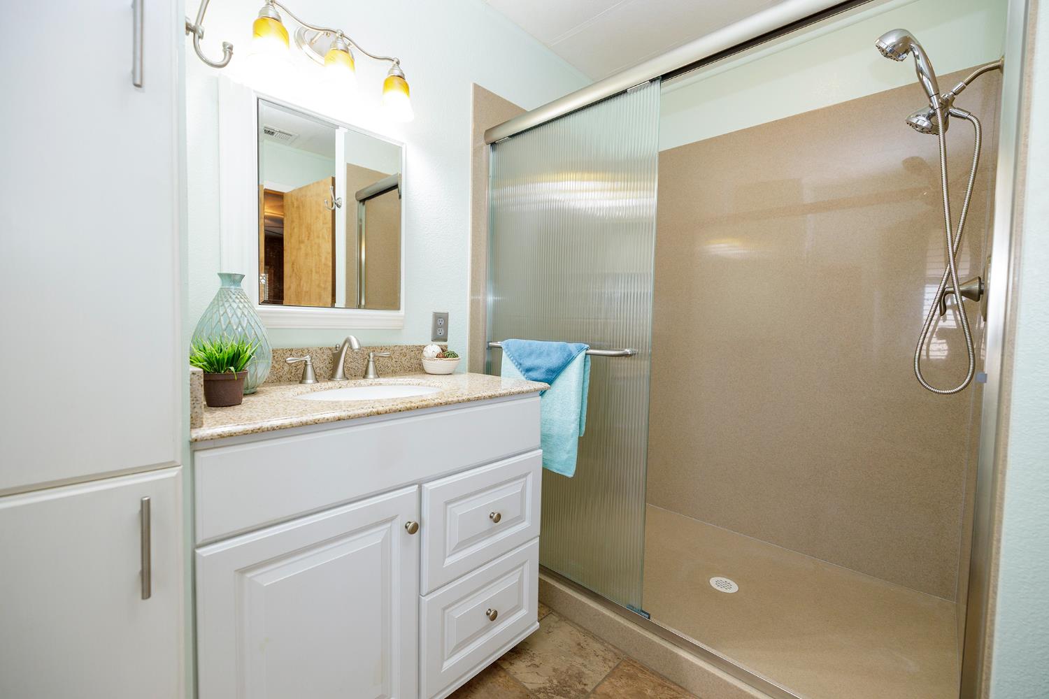 3418 North Waring Road, Unit 24 Denair, CA 95316 - Photo 20 of 48 a bathroom with a shower sink and mirror