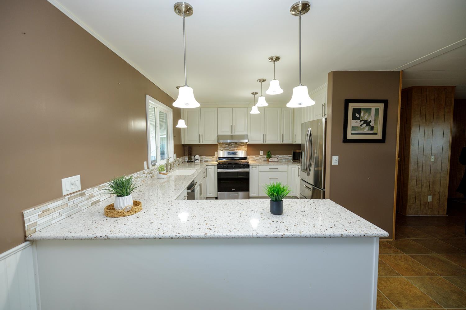 3418 North Waring Road, Unit 24 Denair, CA 95316 - Photo 2 of 48 a kitchen with kitchen island a sink a refrigerator and wooden floor