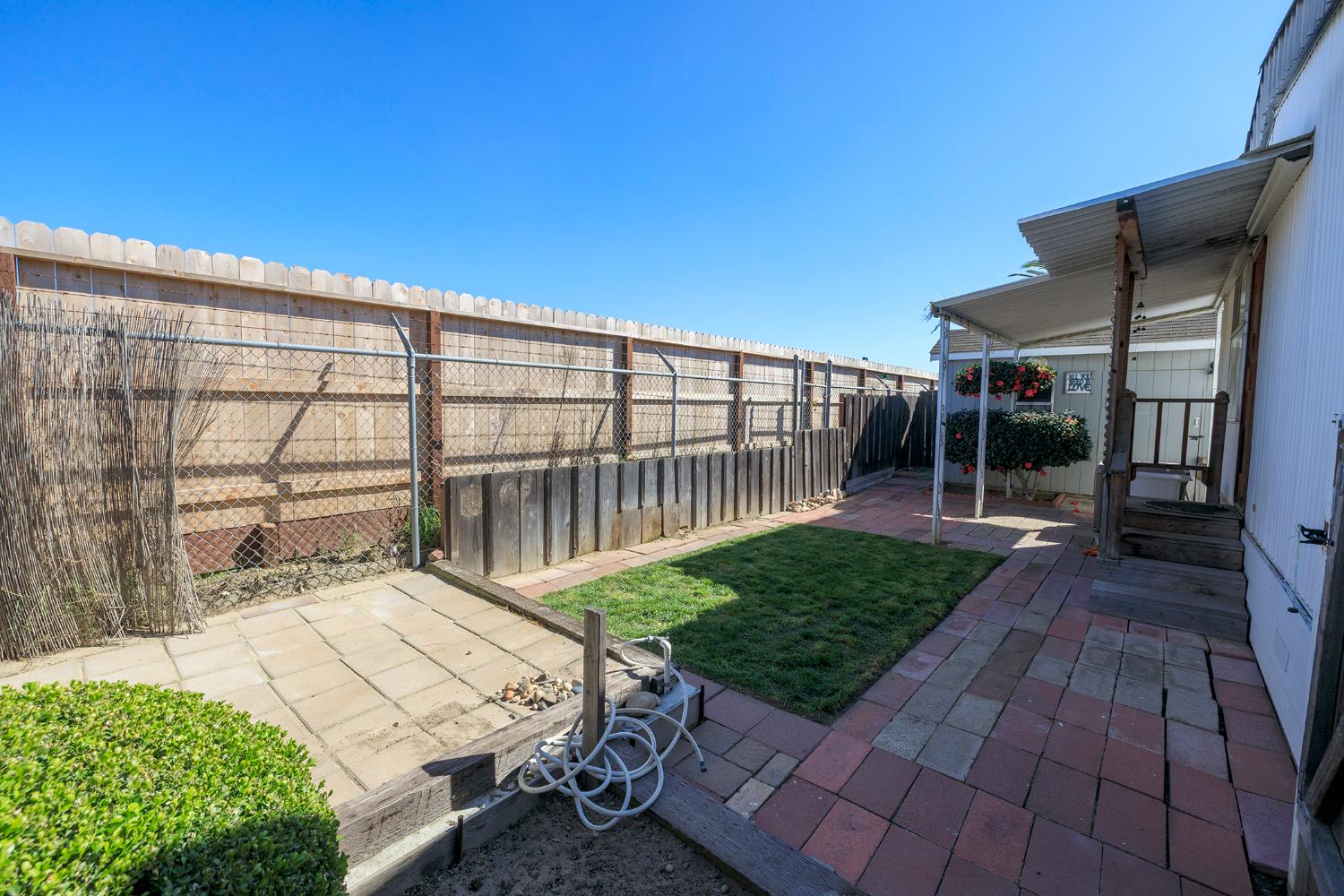 3418 North Waring Road, Unit 24 Denair, CA 95316 - Photo 33 of 48 a view of a backyard with a small deck and a garden